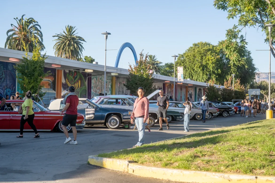 Classic cars parked under the blue Fair entrance arch.