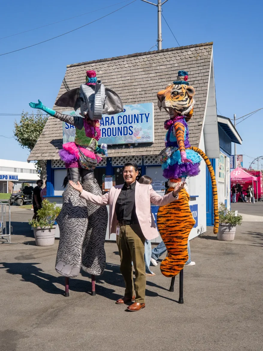 A stilt walker in costume greets visitors near the entrance.