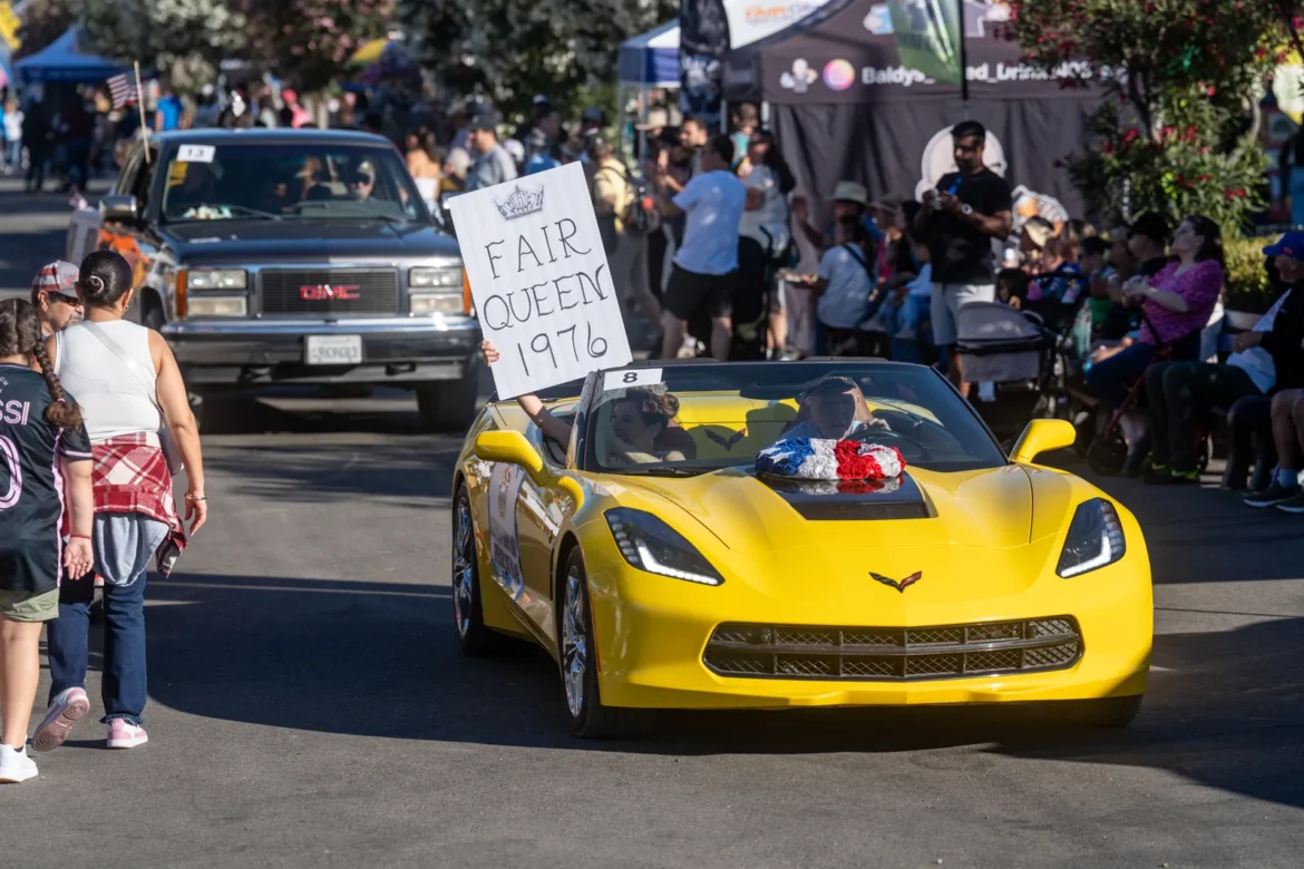 The Fair Queen rides a yellow Corvette in the parade.