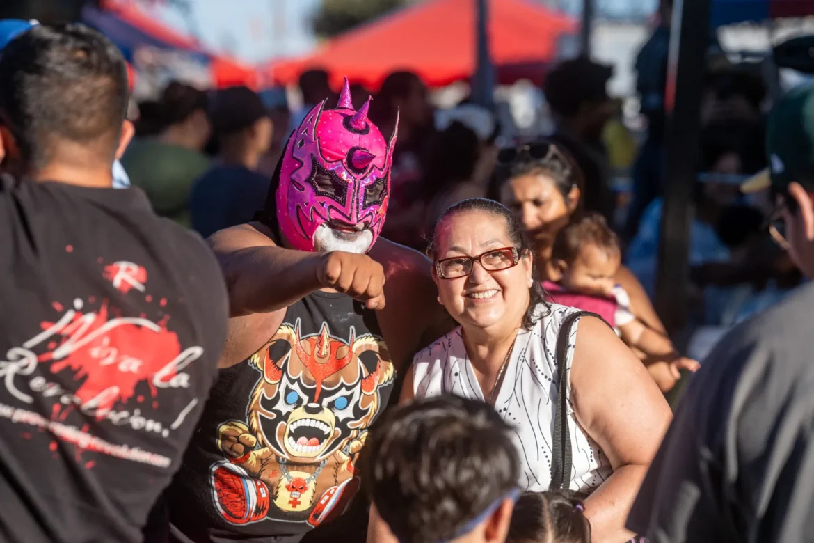 A family wearing lucha libre masks watches the match.