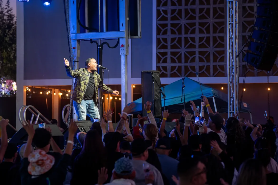 A singer performs to a packed crowd after dark.