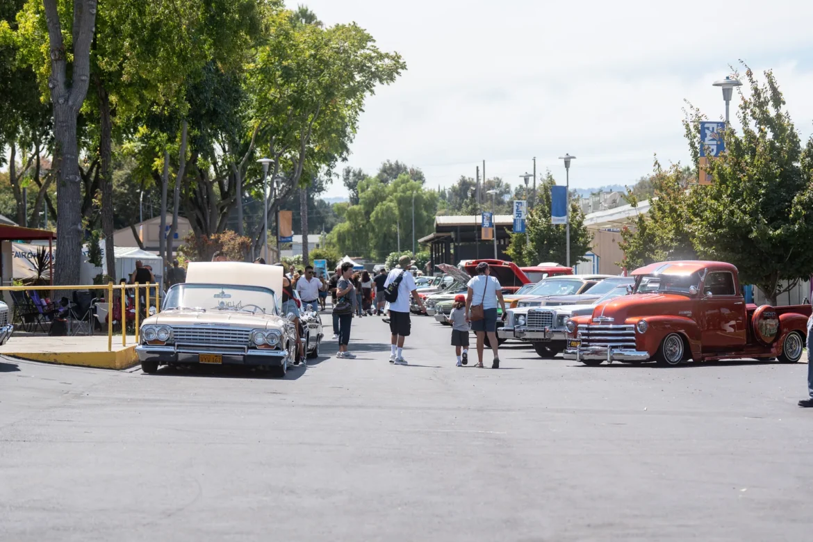 Classic cars lined up along the fairgrounds midway during the car show.