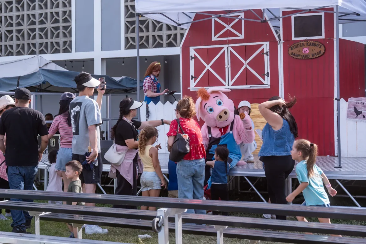 Families watch a show outside the red barn.