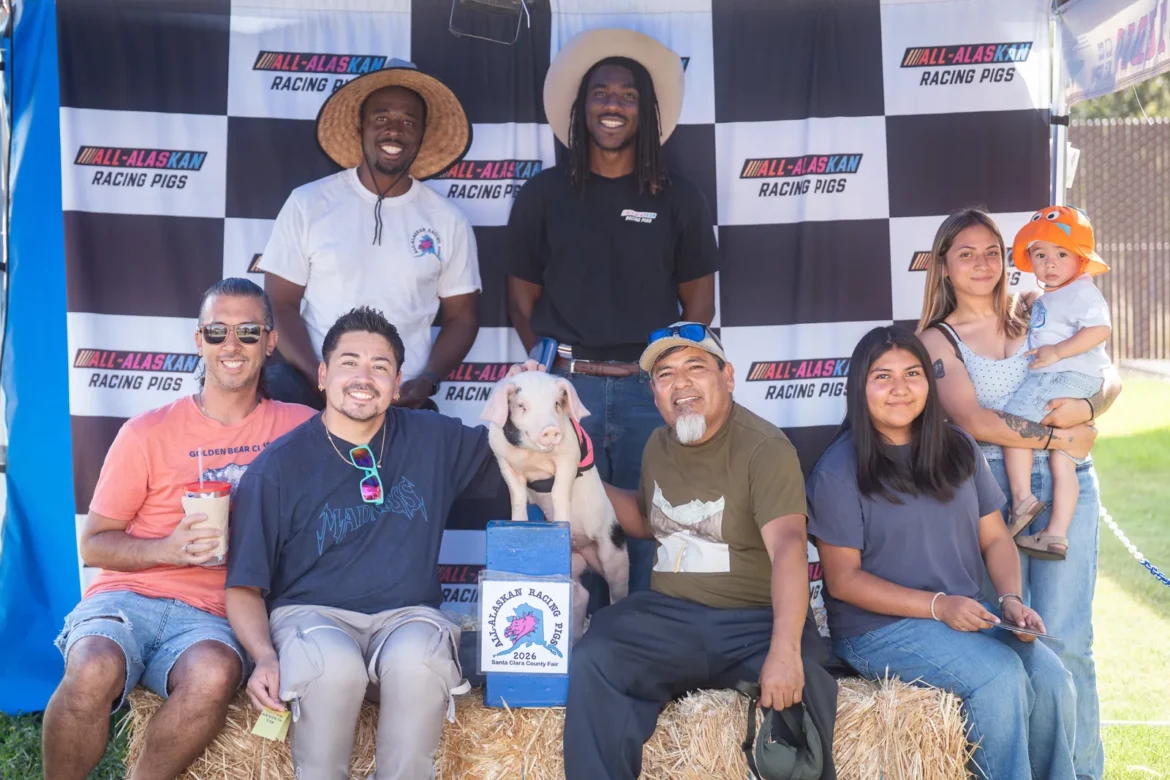 A family poses with the pigs at the Racing Pigs stand.