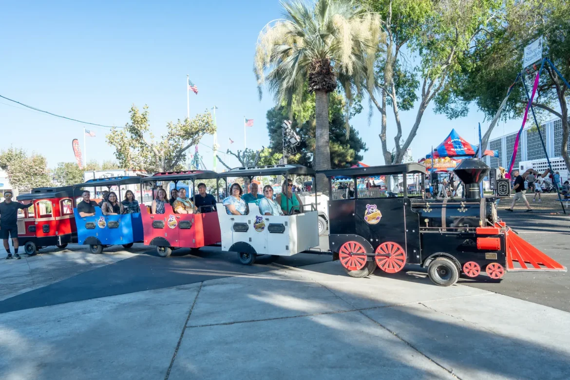 The fairgrounds train carries passengers down the walkway.