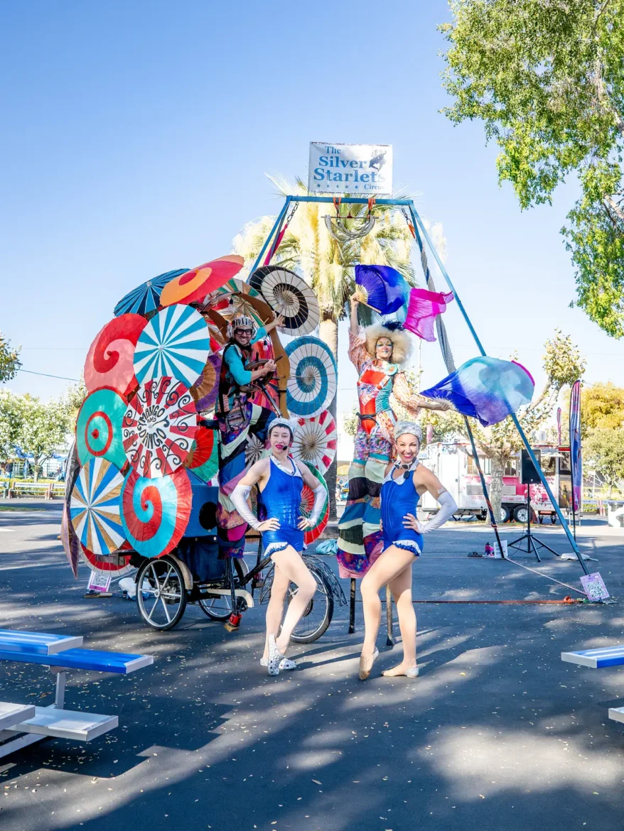 Acrobats perform on a brightly painted mobile stage.