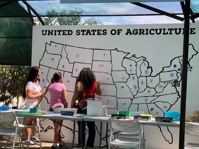Fairgoers add stickers to the United States of Agriculture map.